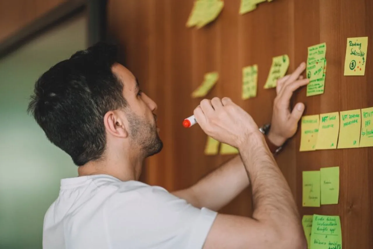 Persona anotando ideas en una pizarra