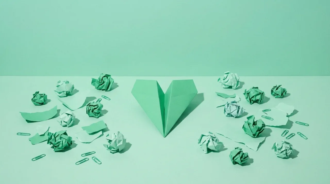 Bodegón en tonos verdes: un avión de papel firme apunta al frente entre papeles arrugados dispersos, metáfora de una marca coherente que no persigue cada tendencia